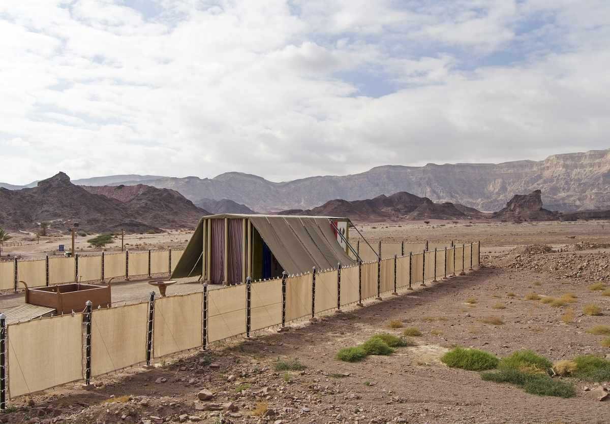 Abri en tissu et clôture dans un environnement aride avec des montagnes en arrière-plan Abri en tissu et clôture dans un environnement aride avec des montagnes en arrière-plan