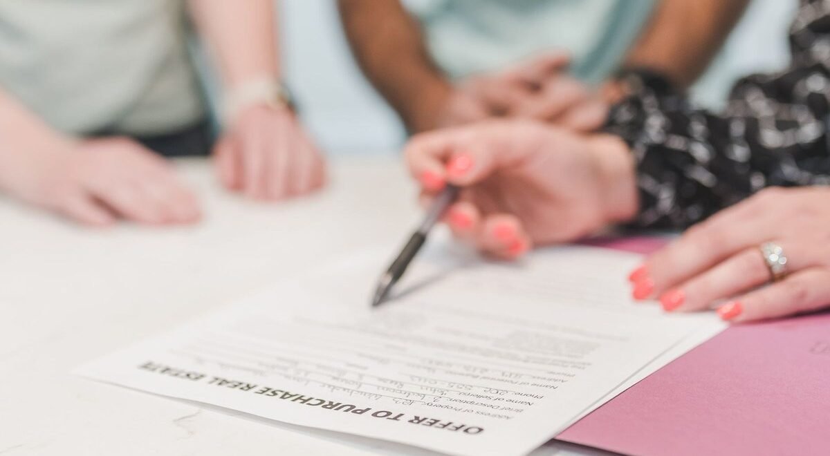 Mains et document sur une table, signature en cours