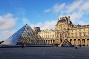 Cour intérieure du Louvre avec sa pyramide de verre moderne et le palais classique en arrière-plan