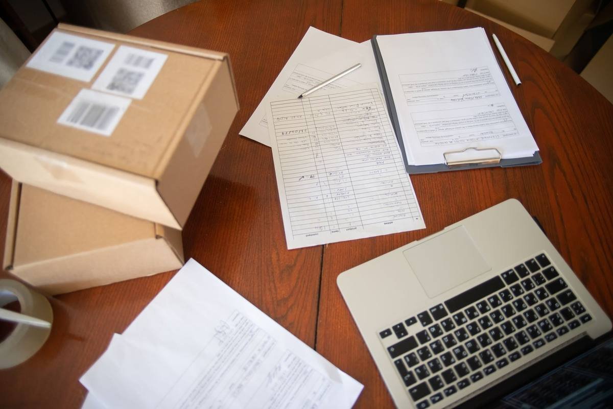 Ordinateur portable, documents et boîtes sur une table en bois Ordinateur portable, documents et boîtes sur une table en bois