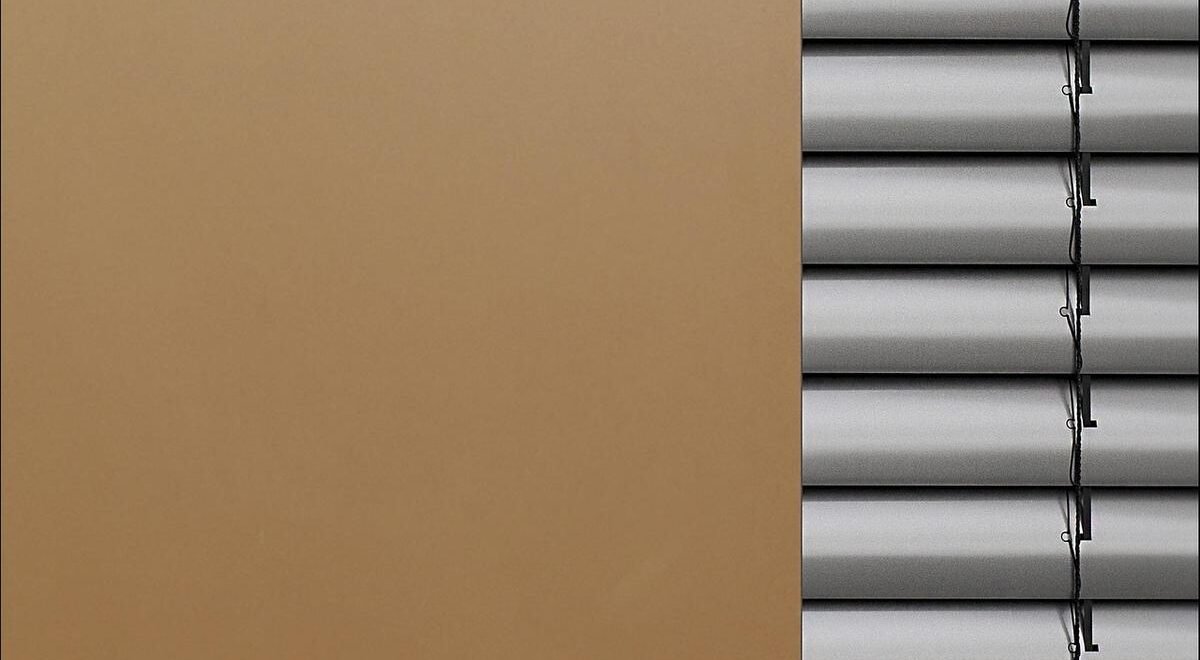 Un mur beige à gauche et des stores métalliques à droite