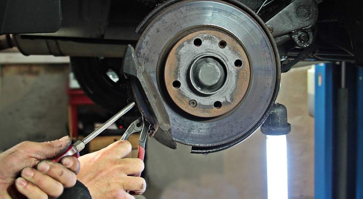 Mains utilisant tournevis et pinces pour retirer disque de frein