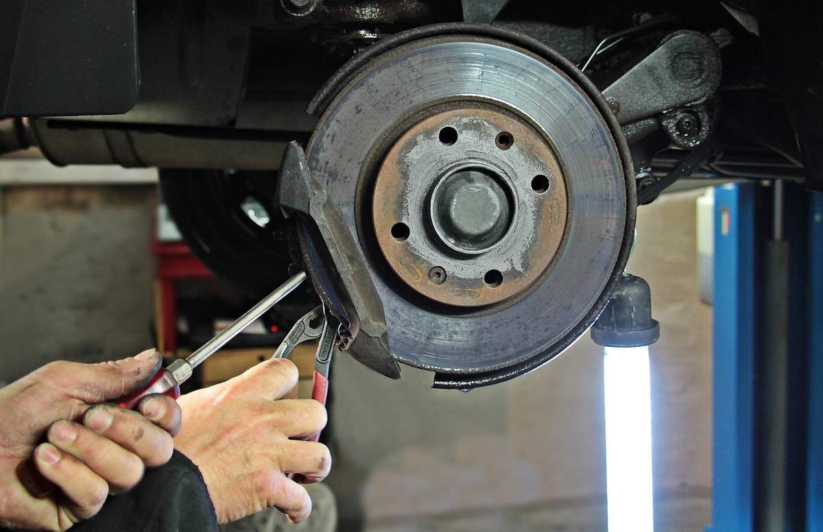 Mains utilisant tournevis et pinces pour retirer disque de frein