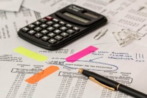 Calculatrice et stylos sur des feuilles de travail