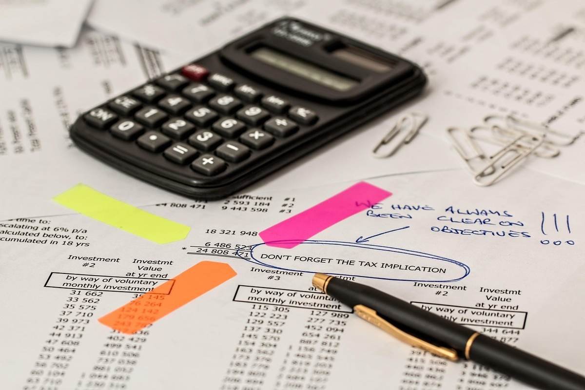 Calculatrice et stylos sur des feuilles de travail