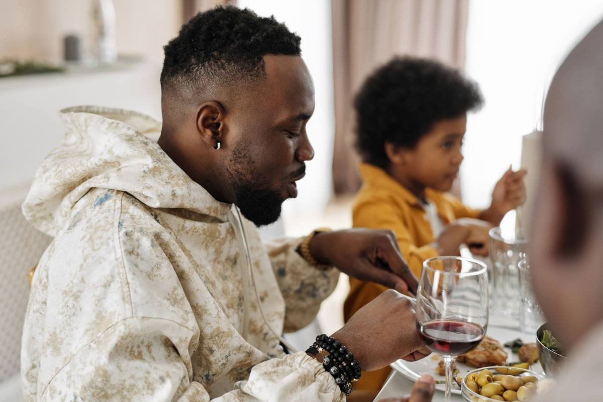 Homme et enfant en train de dîner ensemble autour d'une table Homme et enfant en train de dîner ensemble autour d'une table