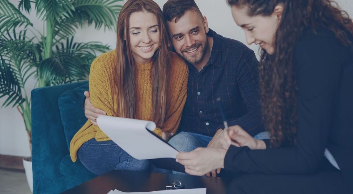 Trois individus examinent un document ensemble dans un intérieur