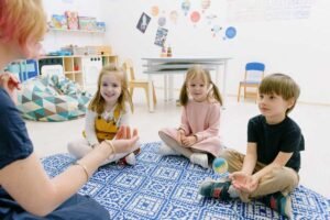 Enfants et adultes assis sur un tapis, jouant avec des objets dans une salle de classe